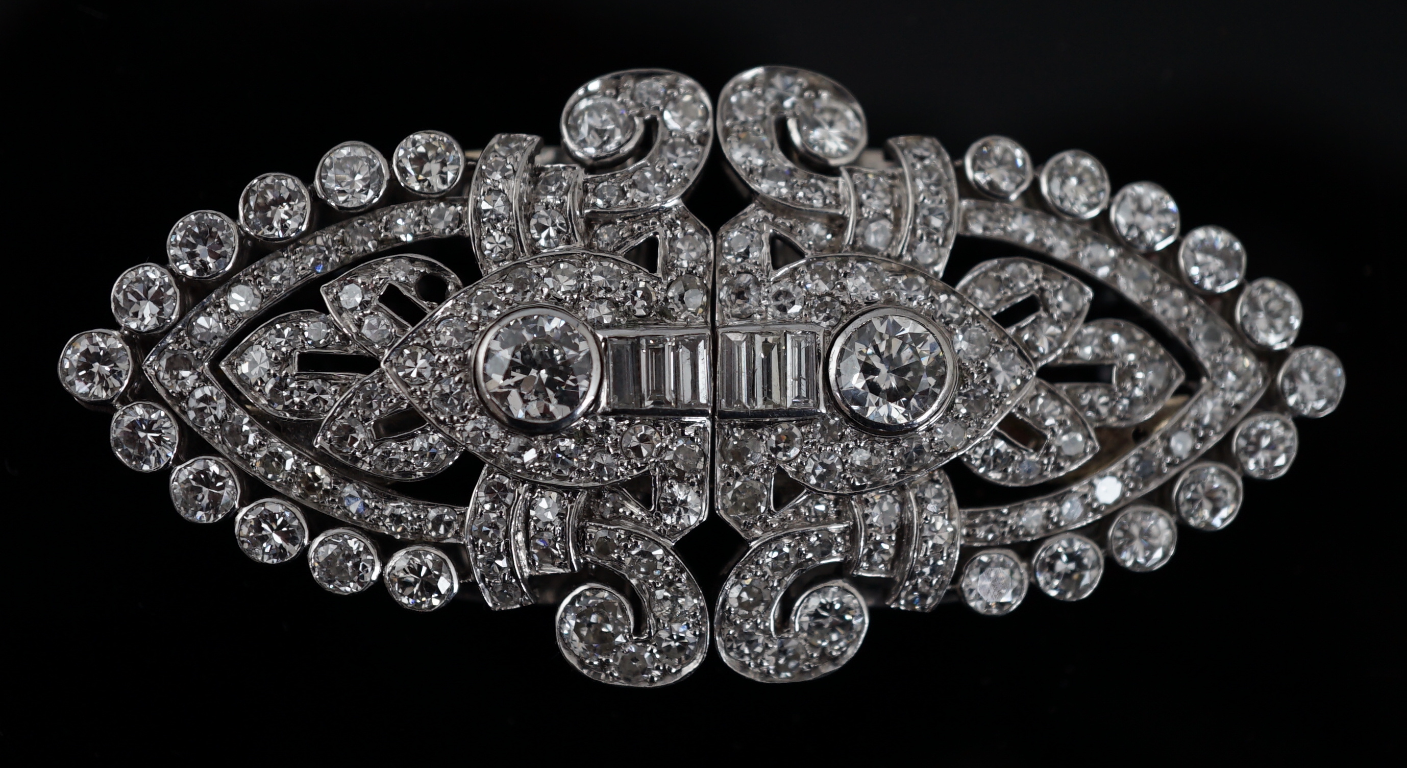 An Art Deco white gold, round and baguette cut diamond set double clip brooch